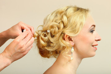Naklejka premium A hairdresser does a hairstyle