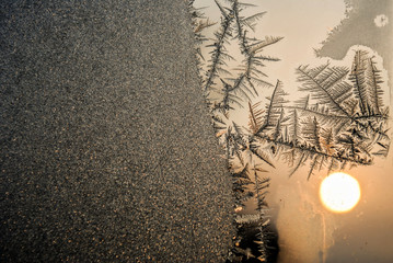 Frost painting magic on the window glass in cold winter morning