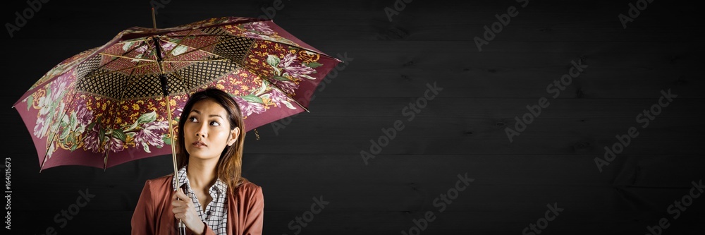 Sticker Millennial woman with patterned umbrella against dark wood panel