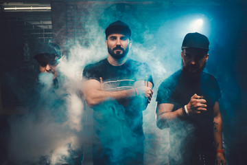 Three men vaping in an authentic room with brick walls