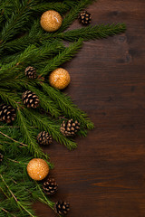 chrismas decorations, larch and fir branches and pine cones on the wood desk.