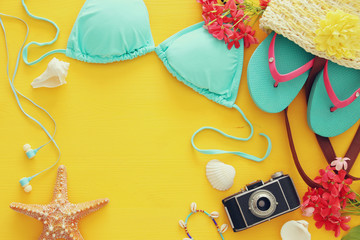 Fototapeta na wymiar fashion female swimsuit bikini on yellow wooden background. Summer beach vacation concept