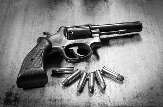 Old short gun and bullets on wooden background