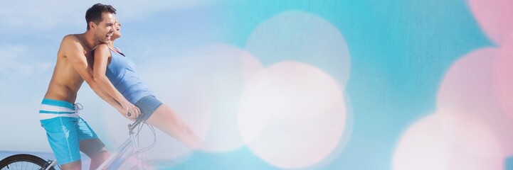 Couple sharing bike in sunshine wide shot