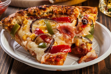 Slices of pizza with bacon, paprika and corn