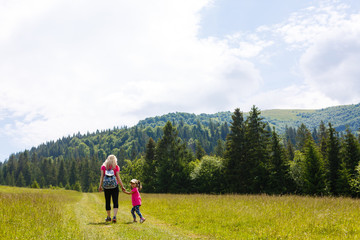Fototapeta na wymiar mother and little daugther hiking in mountains