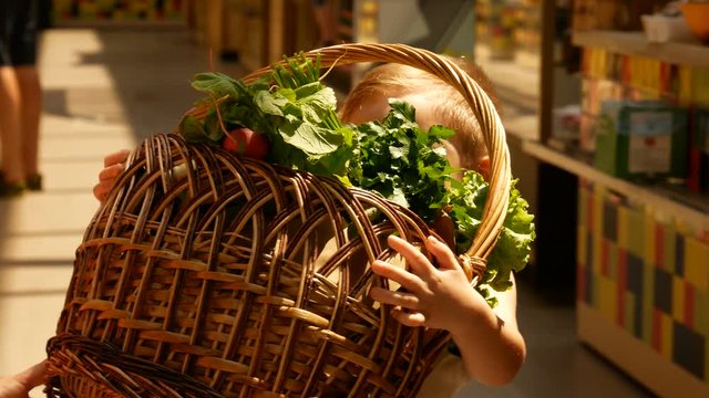 Little boy take the basket with products