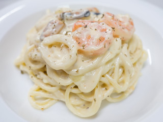 Pasta Carbonara with seafood on a white plate