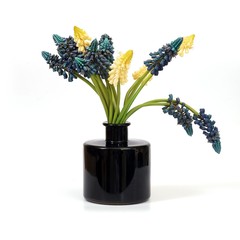 Bouquet of artificial flowers in a black glass vase
