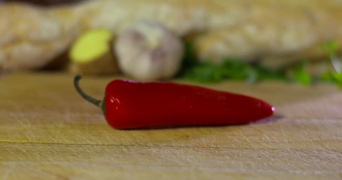 Red Chilli falls onto wooden chopping block