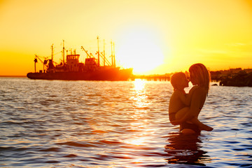 mother and son walking on sunset beach