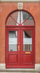 Rote Haustür mit großen Glaselementen