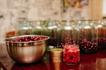 Old machine for rolling metal caps during storage. Preservation of compote from berries