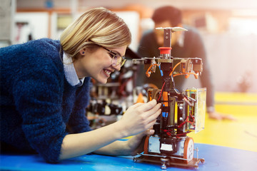 Young engineer testing her robot in workshop