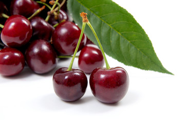White cup with red sweet cherry isolated on a white background..