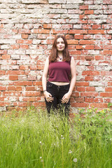 portrait of a young woman with meadow and red wall