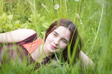 portrait of a young woman lying in a meadow