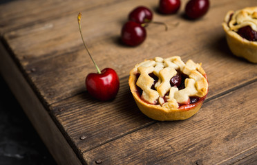 Delicious cherry tartlets on the rustic background. Shallow depth of field.