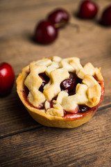 Delicious cherry tartlets on the rustic background. Shallow depth of field.
