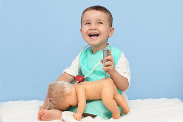 niño disfrazado de médico poniendo una vacuna a un bebé muñeco