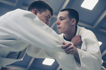 Two young males practicing judo together.