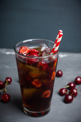 Refreshing cold cherry cola on the wooden background