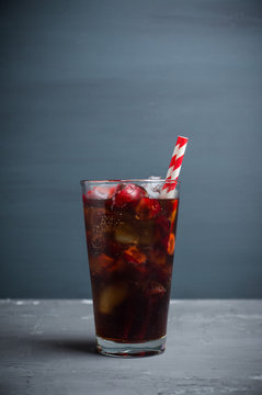 Refreshing cold cherry cola on the wooden background