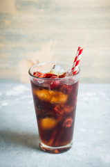 Refreshing cold cherry cola on the wooden background