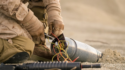 Close-up shot of Soldier Defusing a Bomb by Cutting a Wire During Military Operation in Desert...