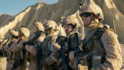 Group of Fully Equipped Soldiers Standing in a Line in the Desert.