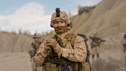 Soldier Preparing a Grenade for Throwing during Combat in the Desert.