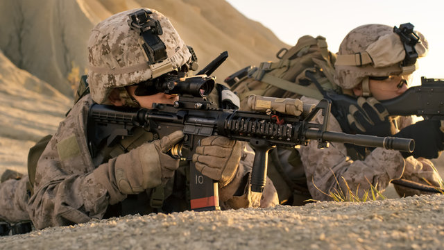 View on Soldiers Lie Down on the Hill, Aim through the Assault Rifle Scope in Desert Environment.