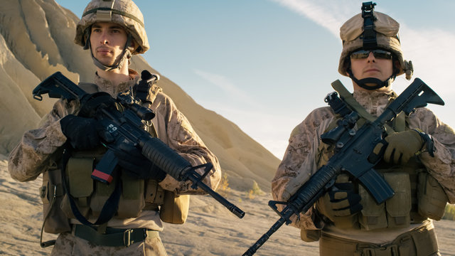 Two Fully Equipped Soldiers Standing in a Line in the Desert.