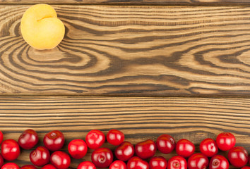 Ripe apricot and many cherry on rustic wooden background