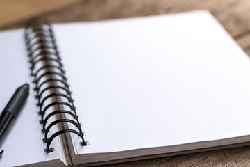 pen and notebook on wooden table.