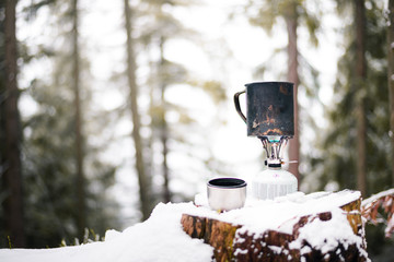 preparing food with a portable gas burner in a winter forest. Bushcraft, hunting and hiking concept