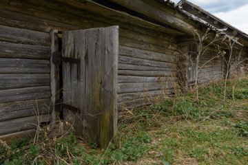 Old dilapidated wooden house with an open door