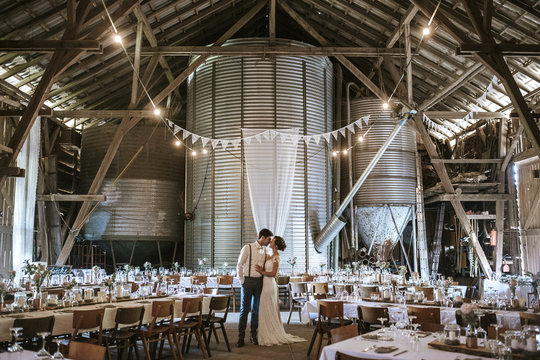 Married Couple kissing in Barn Wedding Location 