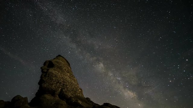 Night stars and Milky Way moving over the Sfinx in Bucegi Natural Park, Romania. 4k timelapse.