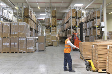 Man in factory hall using pallet jack