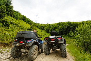 Excited young woman on quad bike. Happy young woman driving all terrain vehicle in nature.