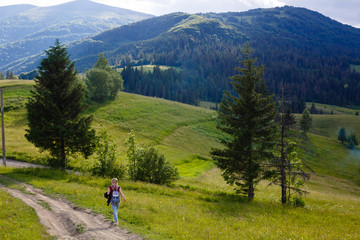 Fototapeta na wymiar The girl walks by herself on a mountain road