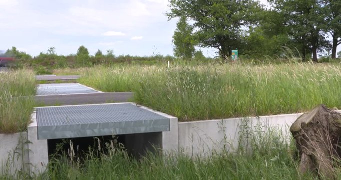 Entrance herpetoduct, a tunnel under the highway N224 for reptiles and amphibians. The concrete fenced embankment should direct small animals to the tunnel. VELUWE, THE NETHERLANDS - MAY 2017
