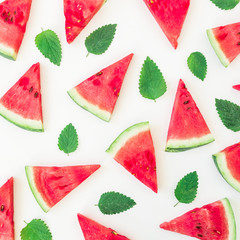 Sliced watermelon and leaves on white background. Flat lay, top view. Fruit pattern