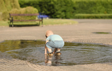 Little boy play in the puddle