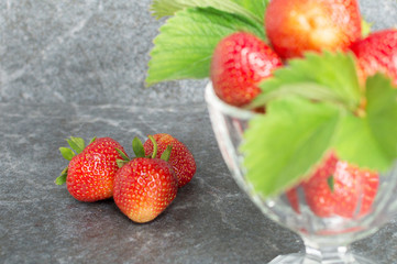 Juicy red strawberries in plates and leaves