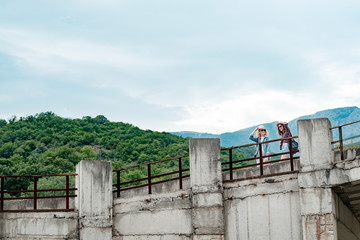 Beautiful mountain landscape, concrete bridge, two girls