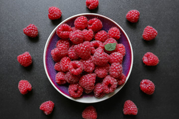 fresh raspberries in a bowl on black background