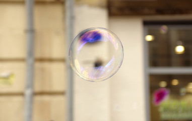 Multi-colored soap bubble against the building background