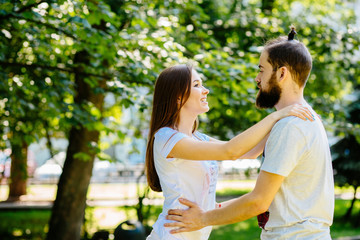 Fototapeta premium Beautiful bearded man biting the woman's cheek. The concept of tenderness and affection